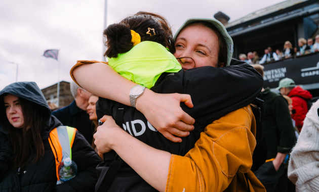 Two people hugging looking happy - Dig & Dig