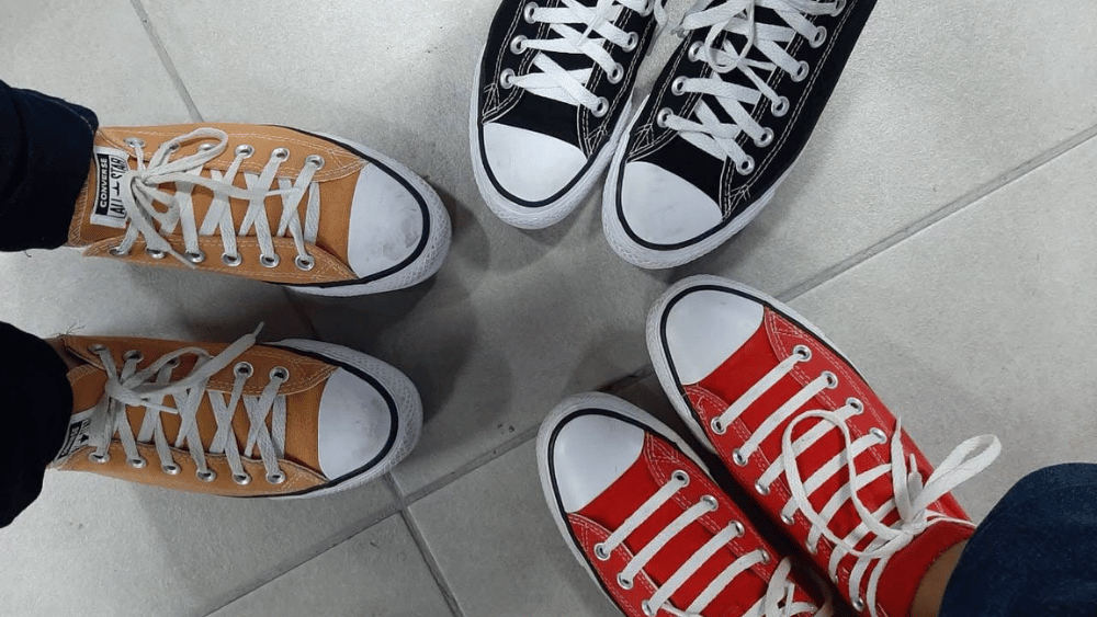 3 pairs of feet in a circle wearing the same brand trainers - Dig & Dig