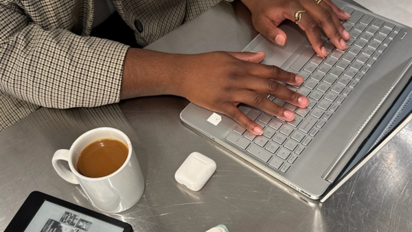 Woman sitting at table with a coffee typing on laptop - Dig & Dig