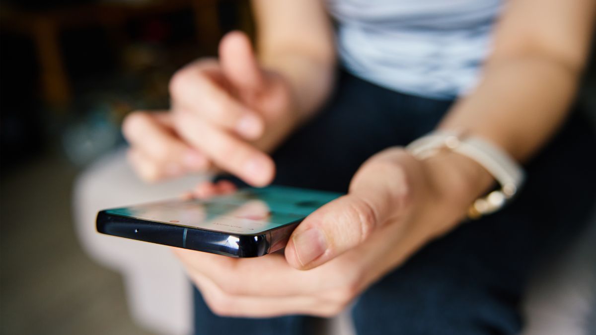 Person scrolling on smartphone researching paid social vs programmatic - Dig & Dig